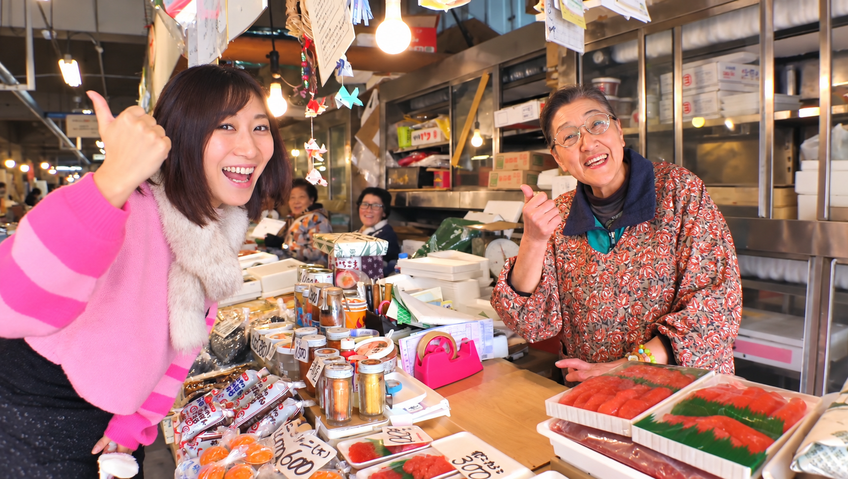 八戸の市場で地元のお店の方と笑顔で親指を立てるJunko☆