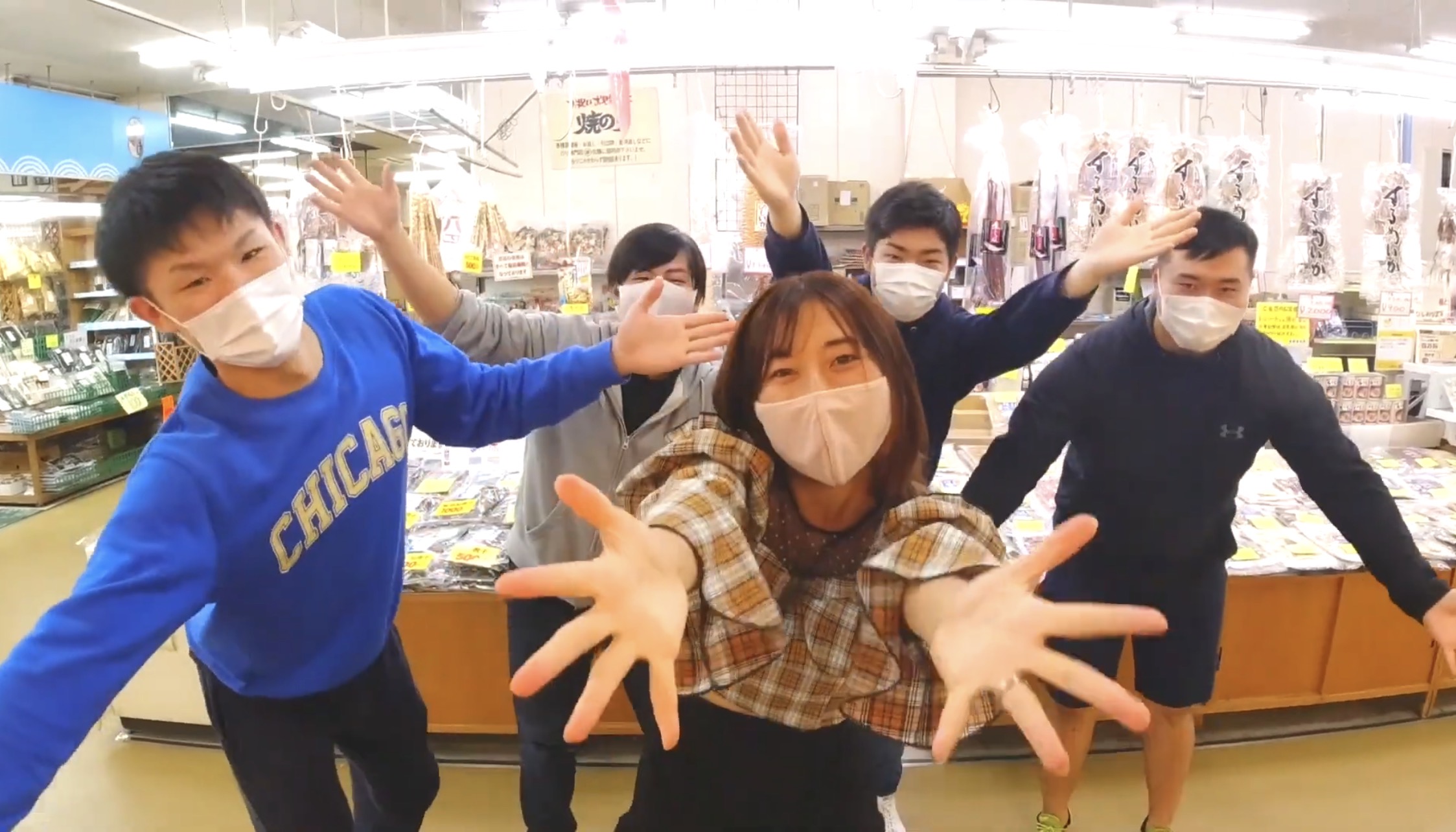 八食センターの売り場で学生のみなさんと出演者が手を広げて踊る様子