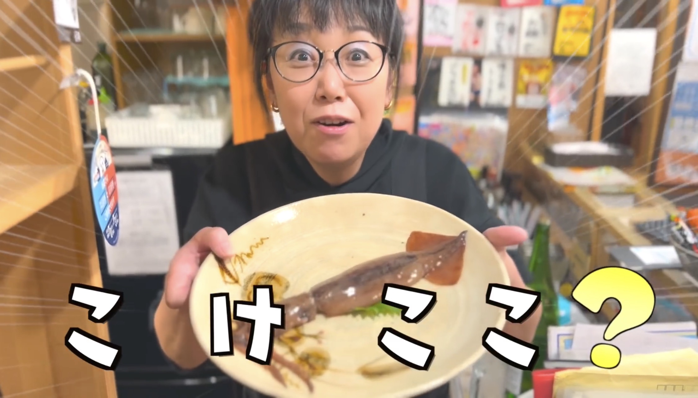 撮影当時のみろく横丁「きちょこ」で、イカを載せた皿を差し出すおかみさん